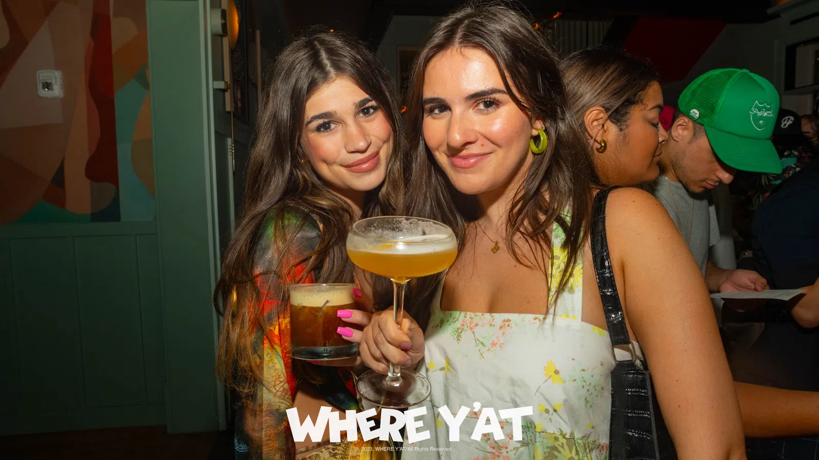 two women holding drinks