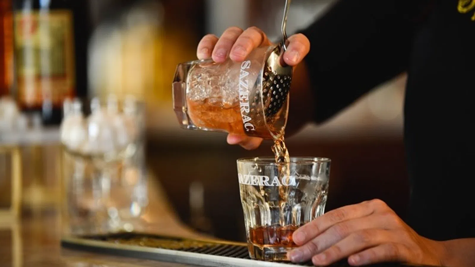 a person pouring a liquid into a glass