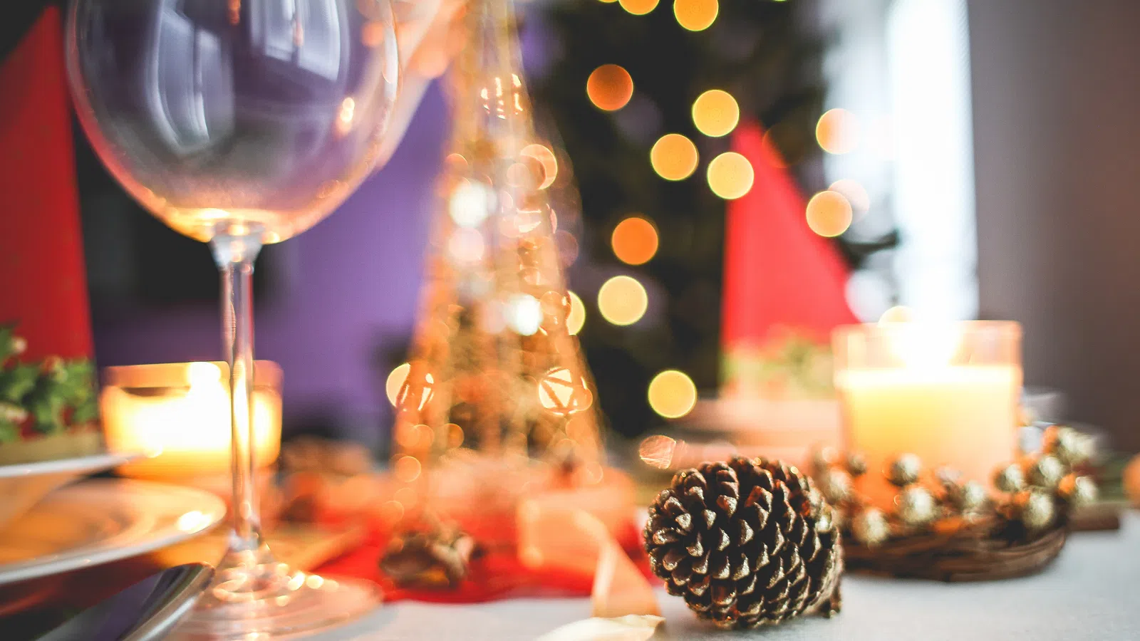 a glass of wine next to a decorated tree