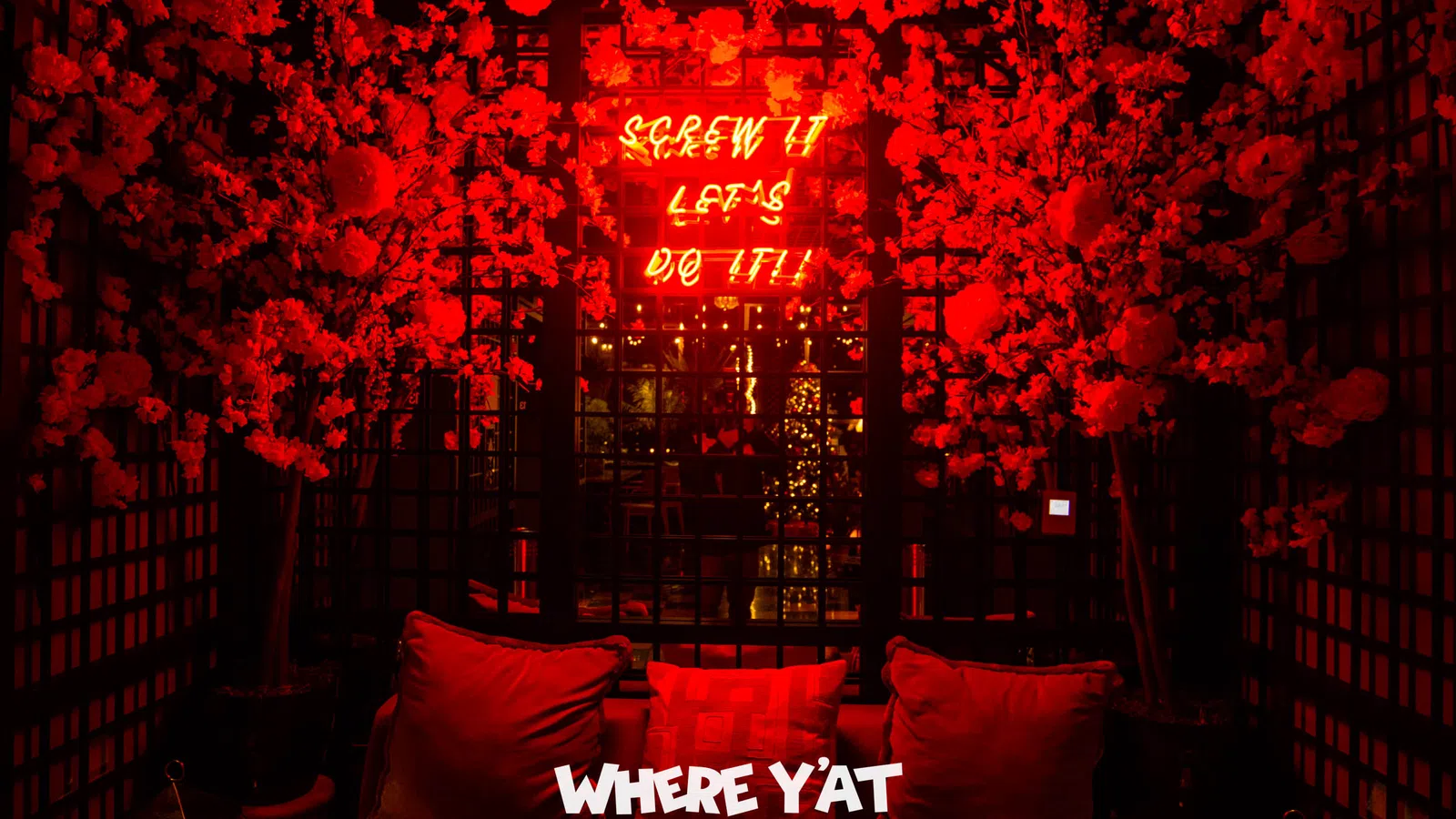 a couch with red pillows and a sign above it