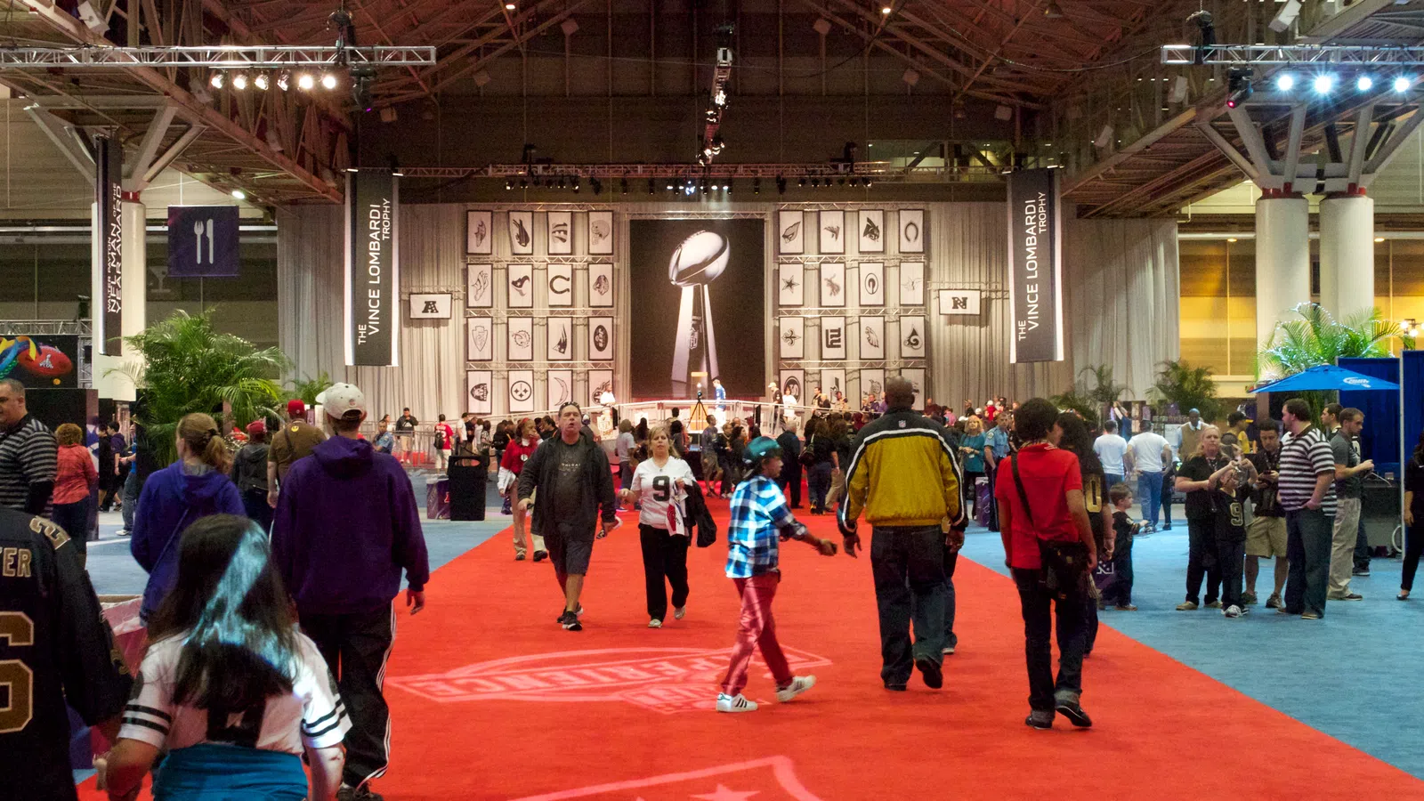 a group of people in a large room with a statue on the wall