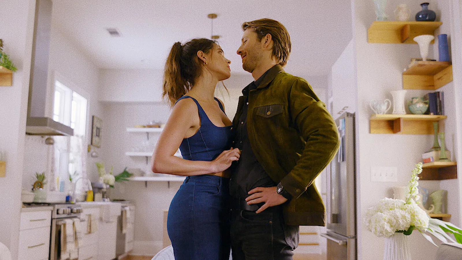 a man and woman kissing in a kitchen