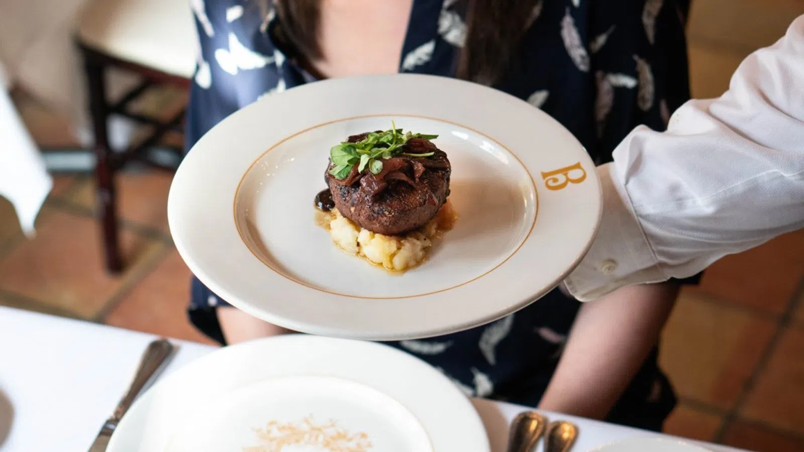 a person sitting at a table with a plate of food