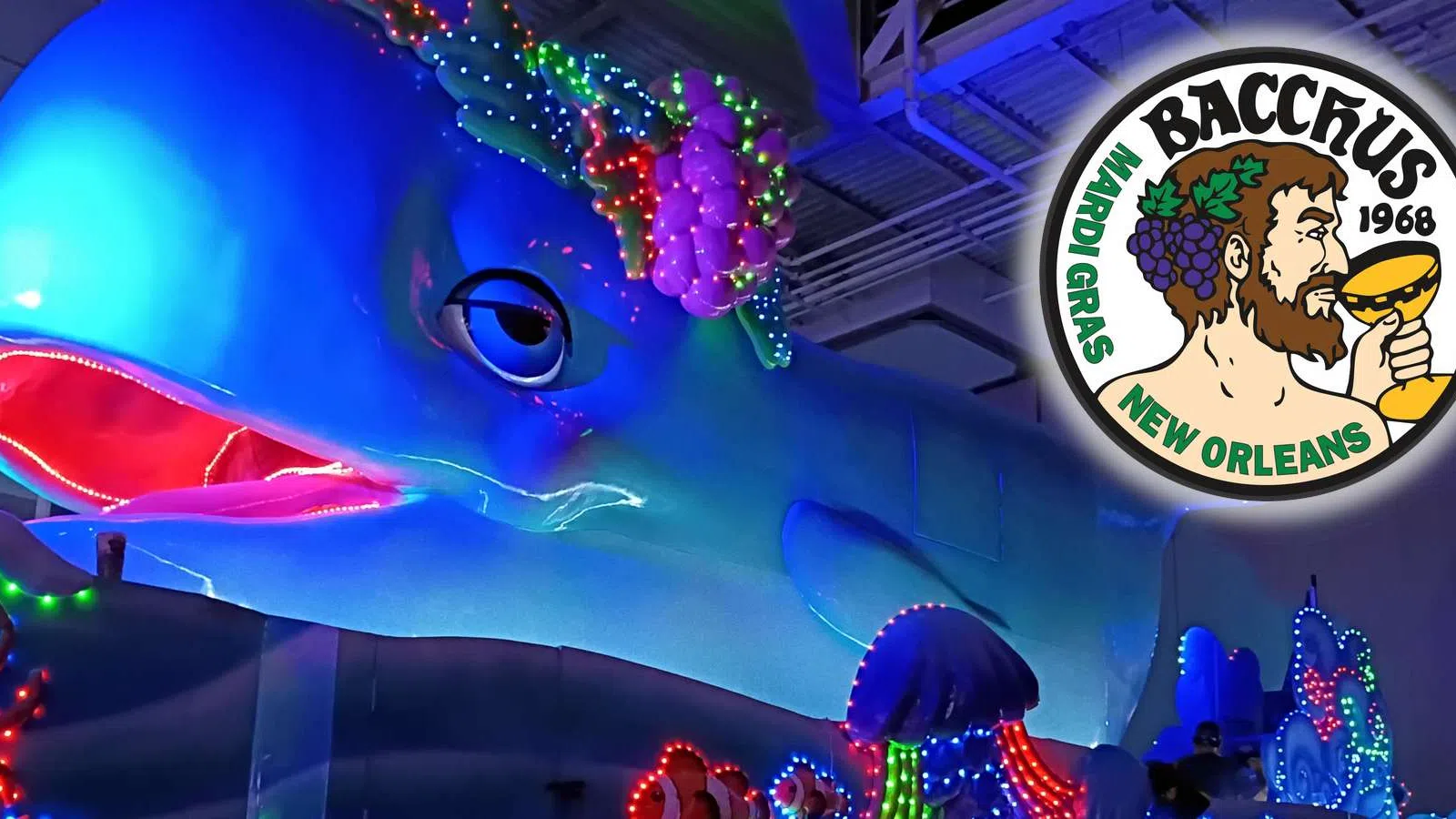 Large blue dolphin float decorated with colorful lights at Bacchus Mardi Gras parade in New Orleans.