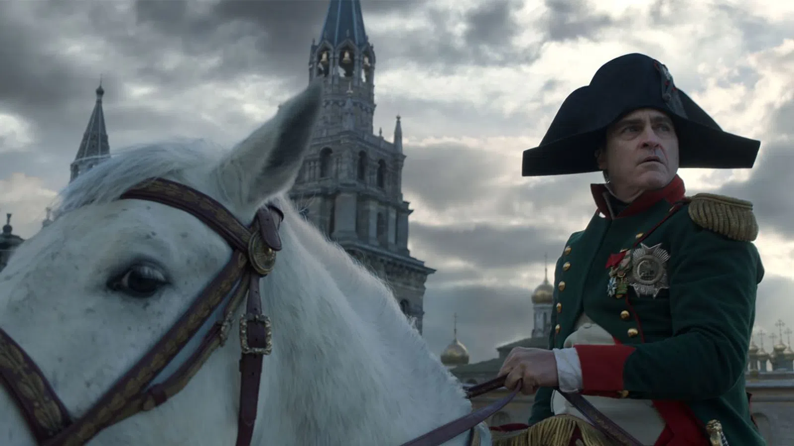 a man in a hat and coat standing next to a white horse