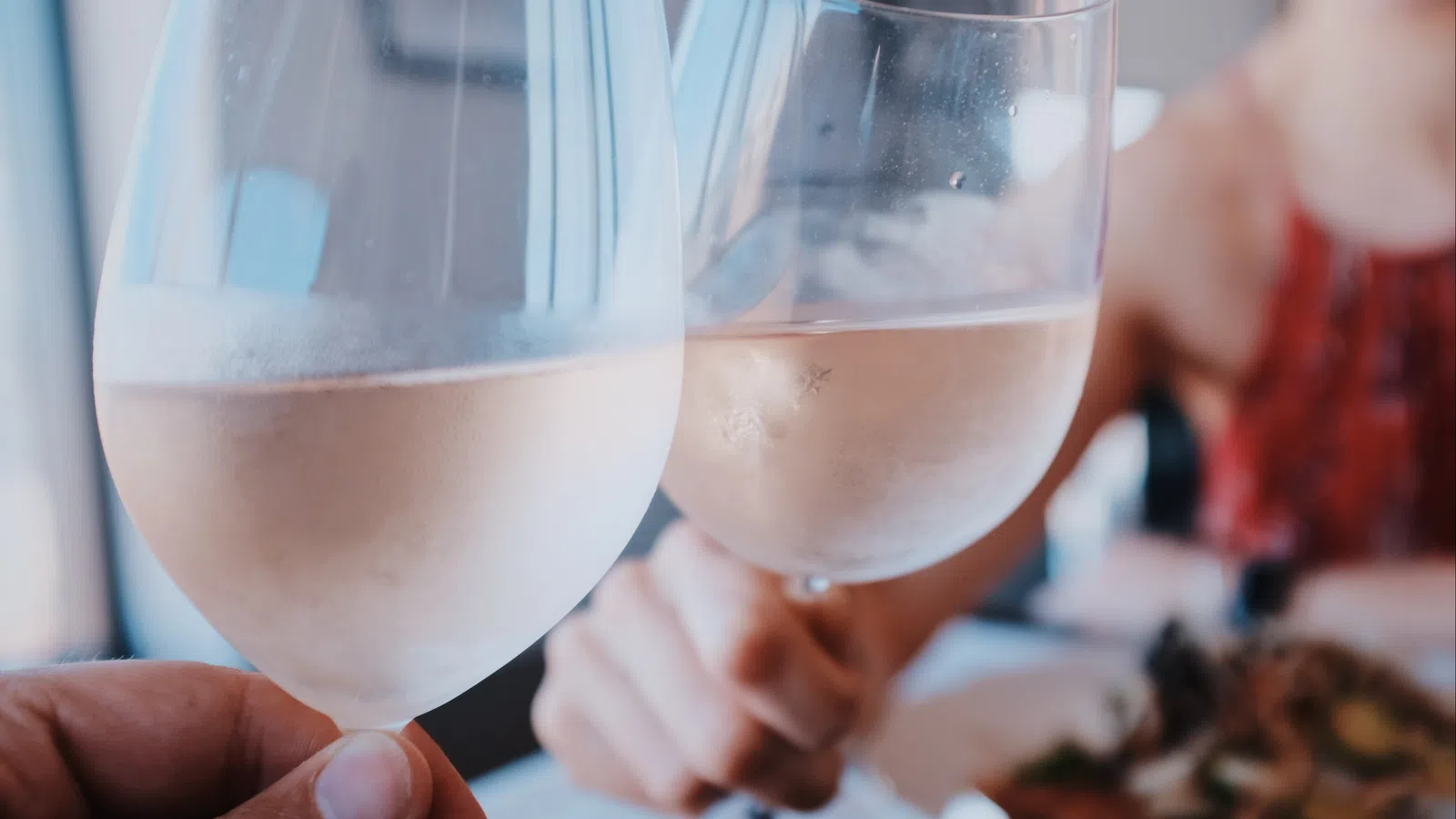 a couple of people hold wine glasses