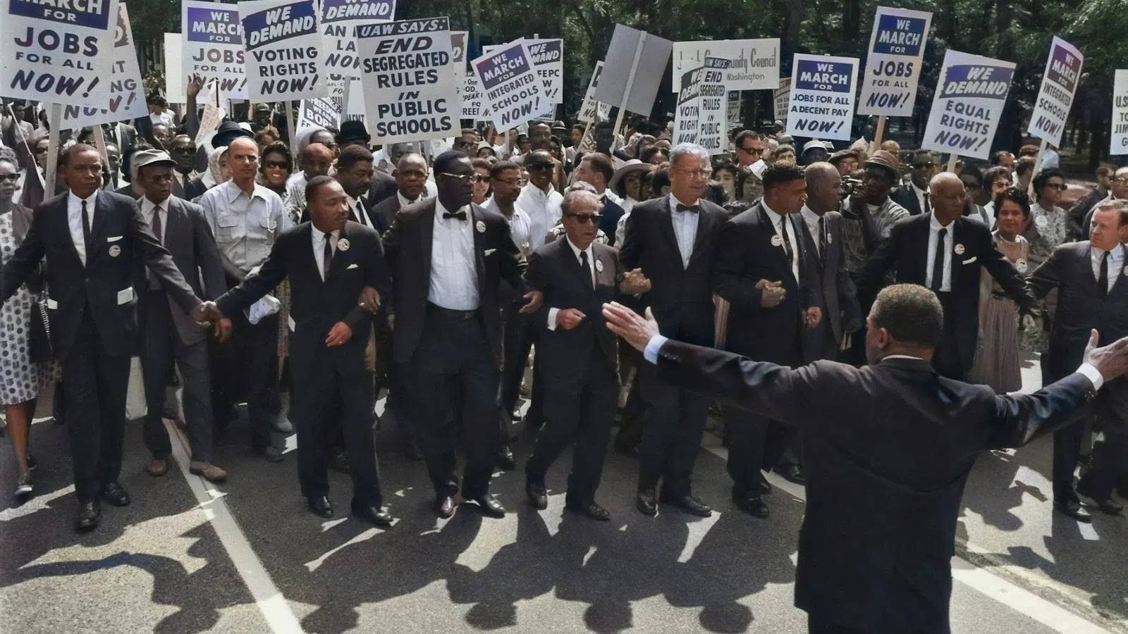 a person holding a sign in front of a group of people