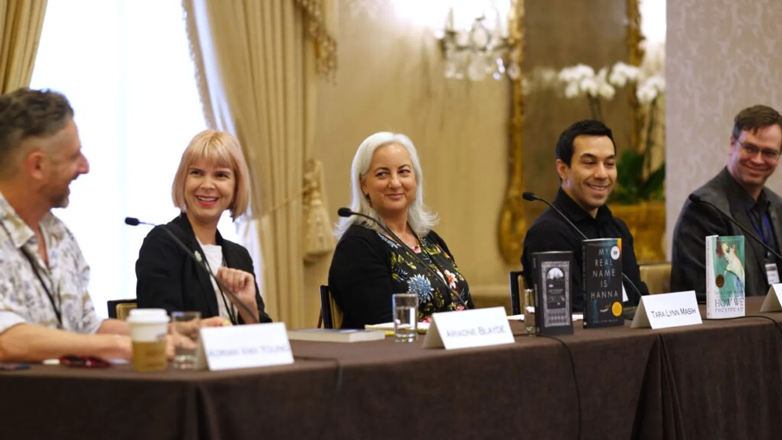 Tara L. Masih et al. sitting at a table with microphones