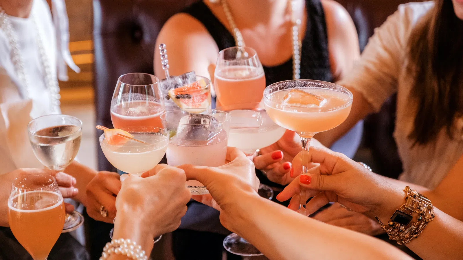 a group of people holding glasses of liquid