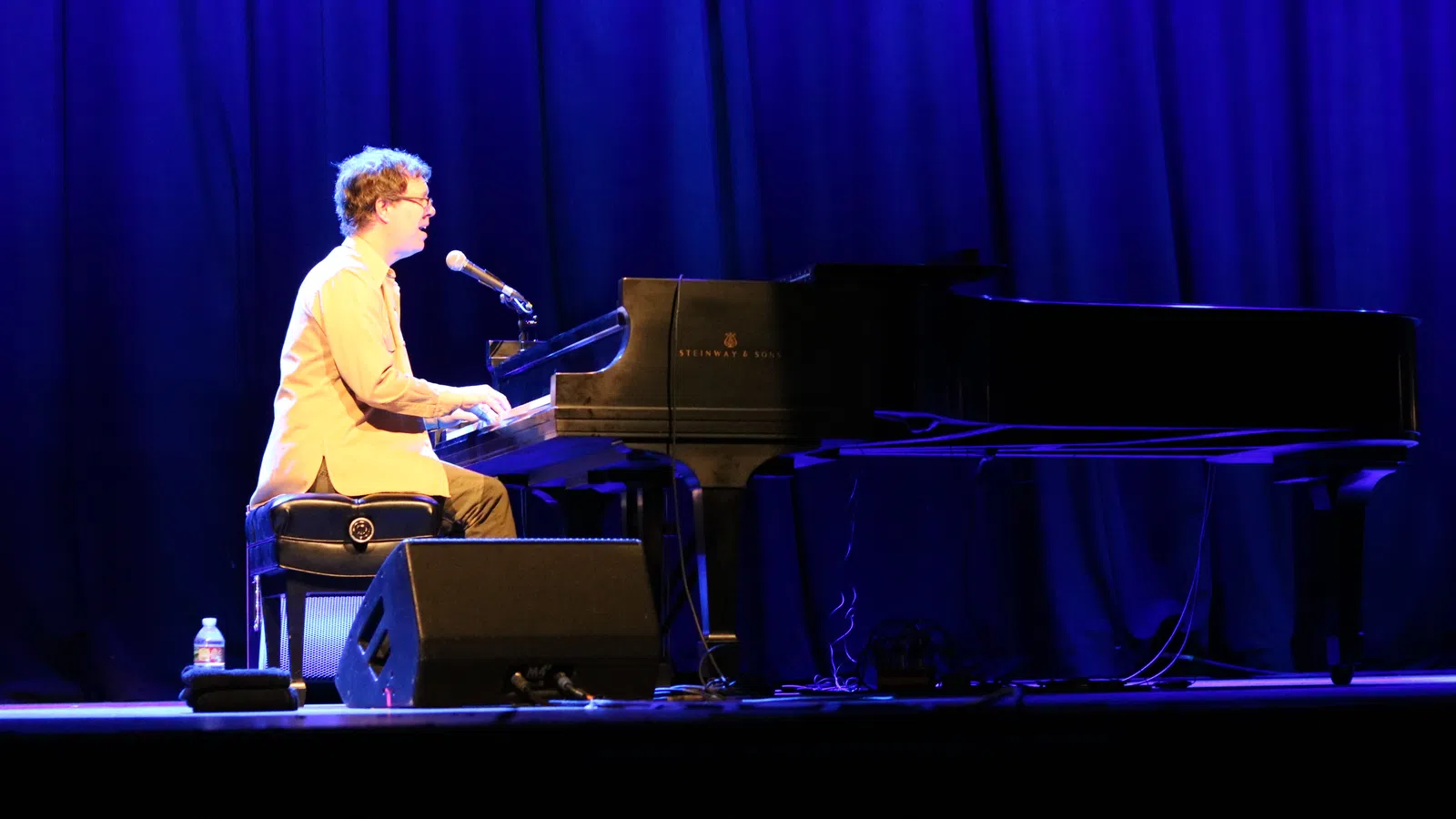 a man playing a piano on a stage
