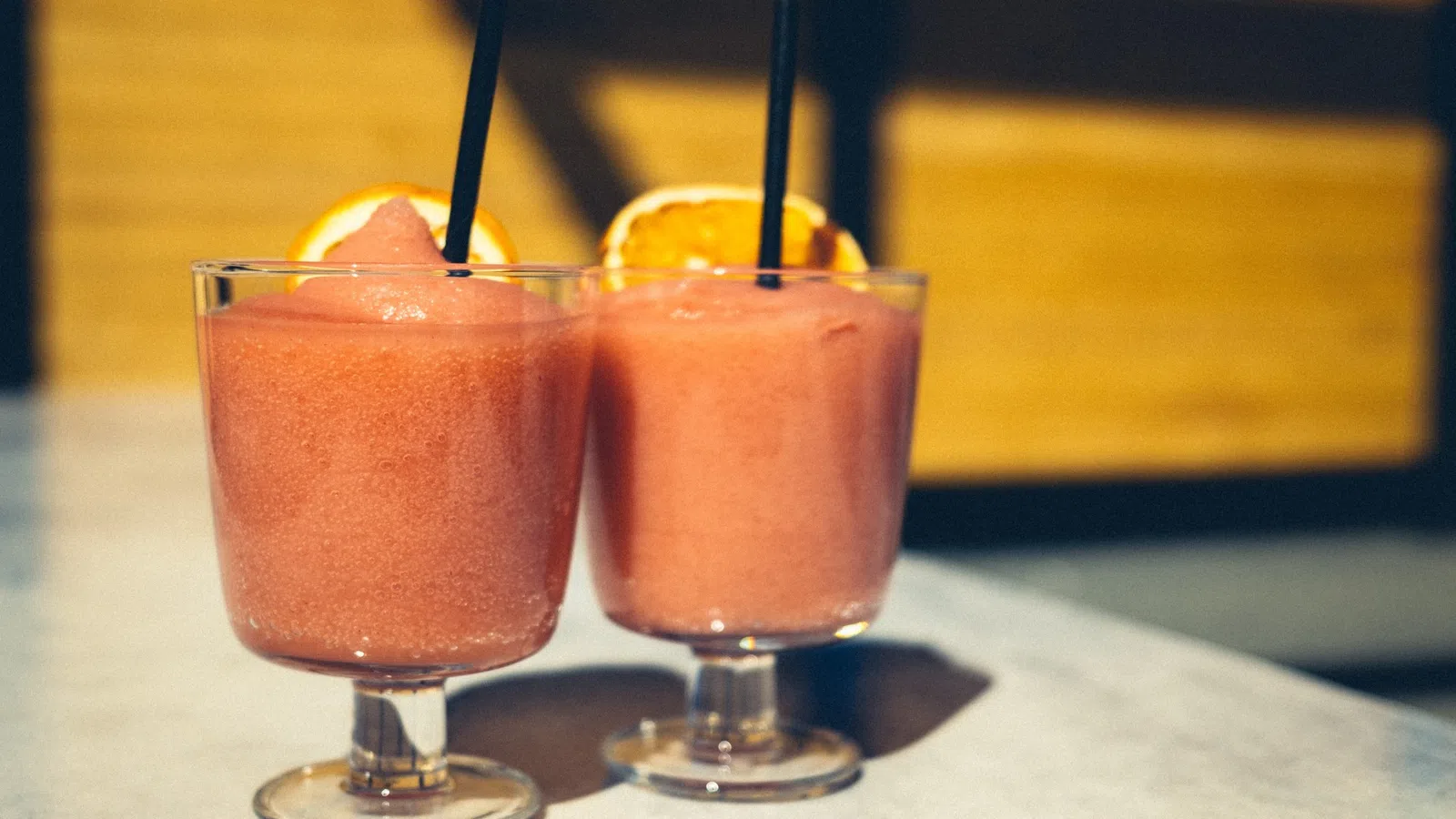 two glasses of drinks with straws