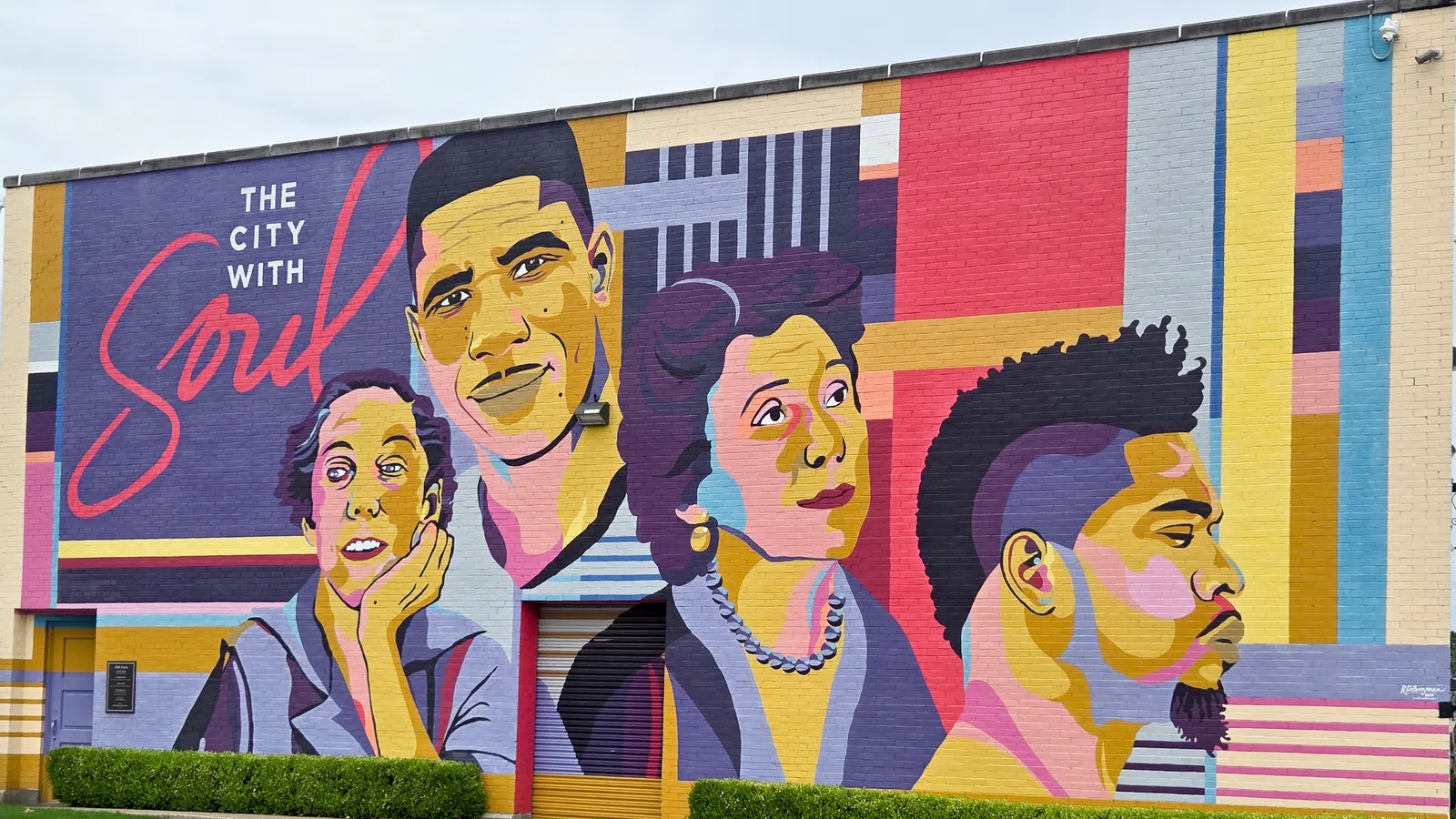 Colorful mural on a building wall depicting diverse faces with the text The City With Soul in vibrant colors.