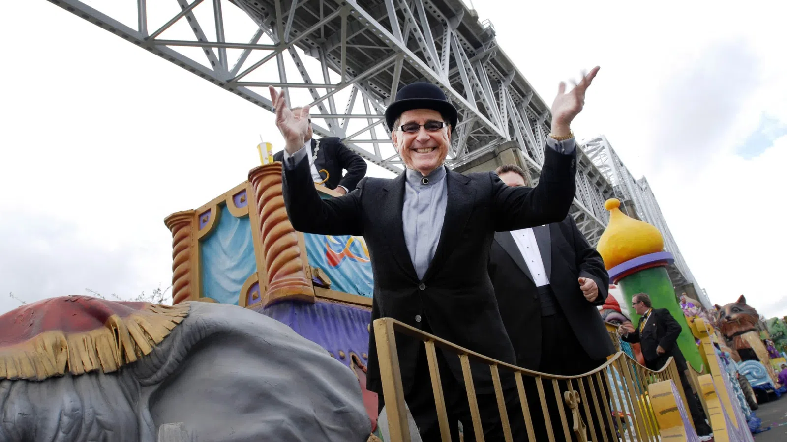 a person in a black hat and suit standing on a roller coaster