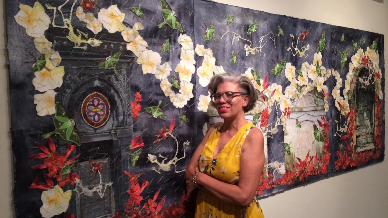 a person standing in front of a wall with flowers