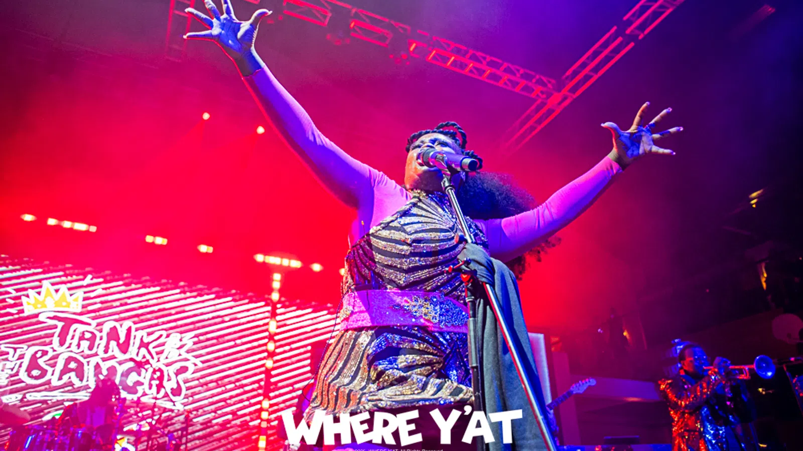 a person on stage with the arms raised