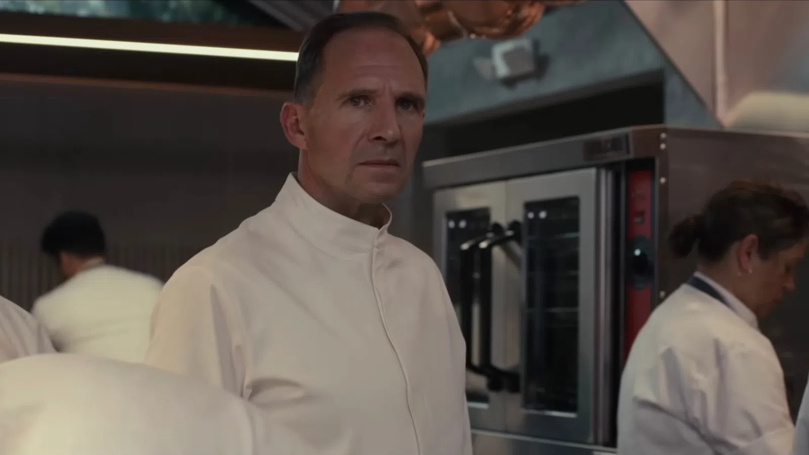 Ralph Fiennes wearing a white coat