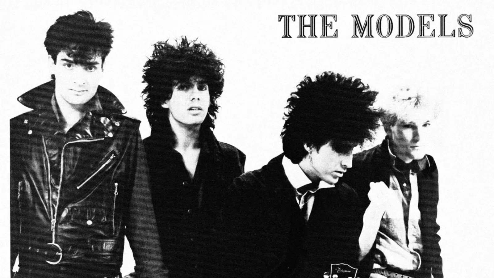 Black and white photo of four 1980s punk rock band members with distinctive hairstyles and leather jackets.