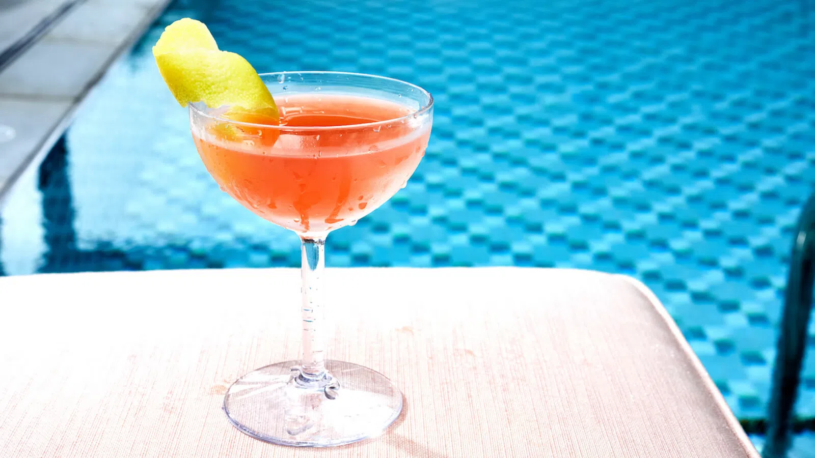 a glass of orange drink with a slice of lemon on top