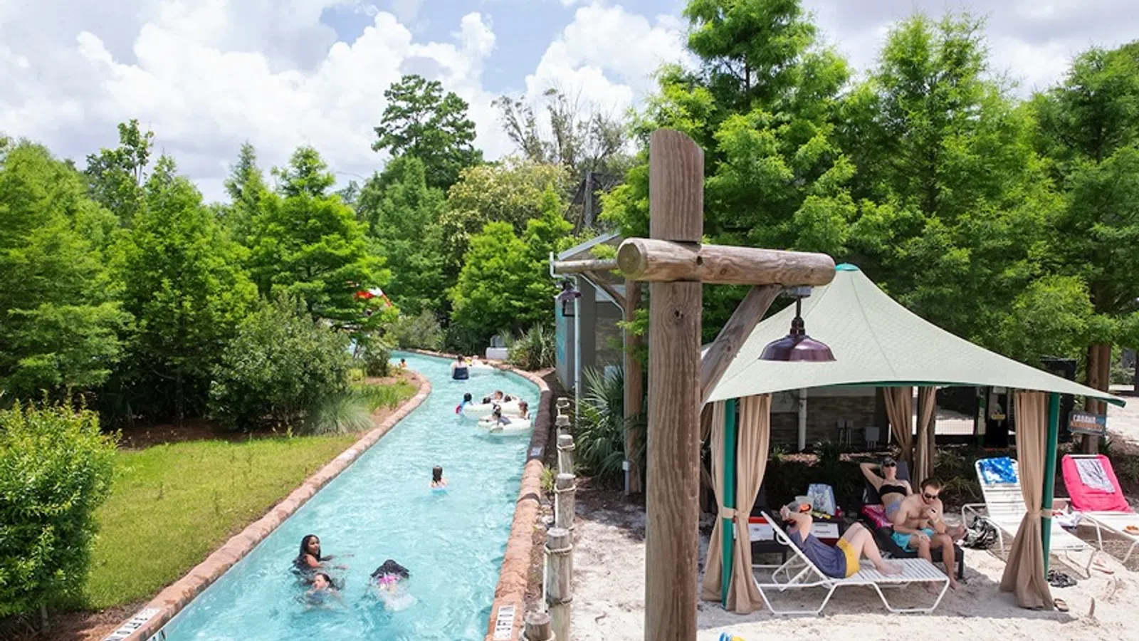 a pool with people in it and a gazebo with trees in the background