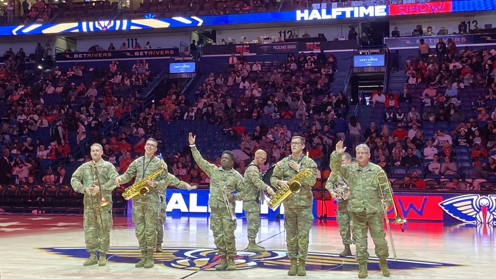 a group of men in green uniforms holding up their hands