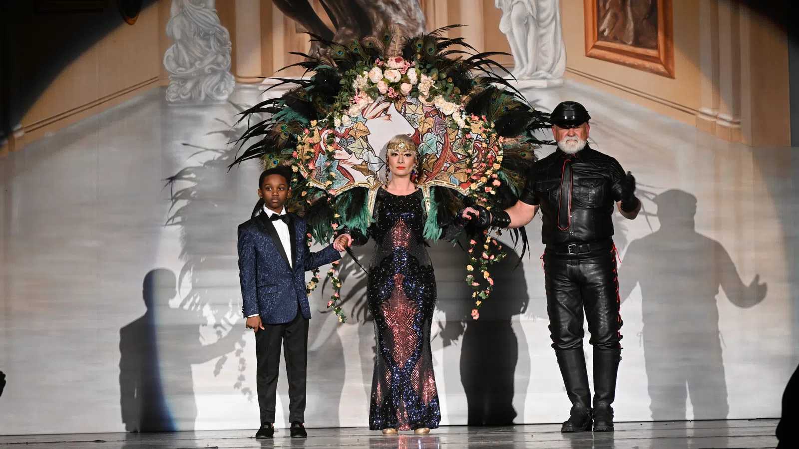 a group of people standing on a stage with a large bouquet of flowers