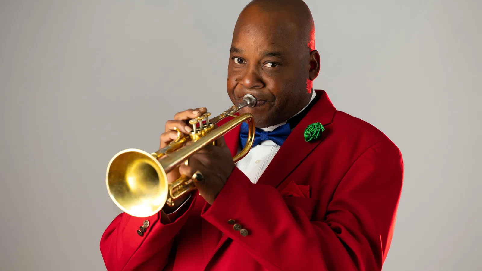 a man in a red uniform playing a trumpet
