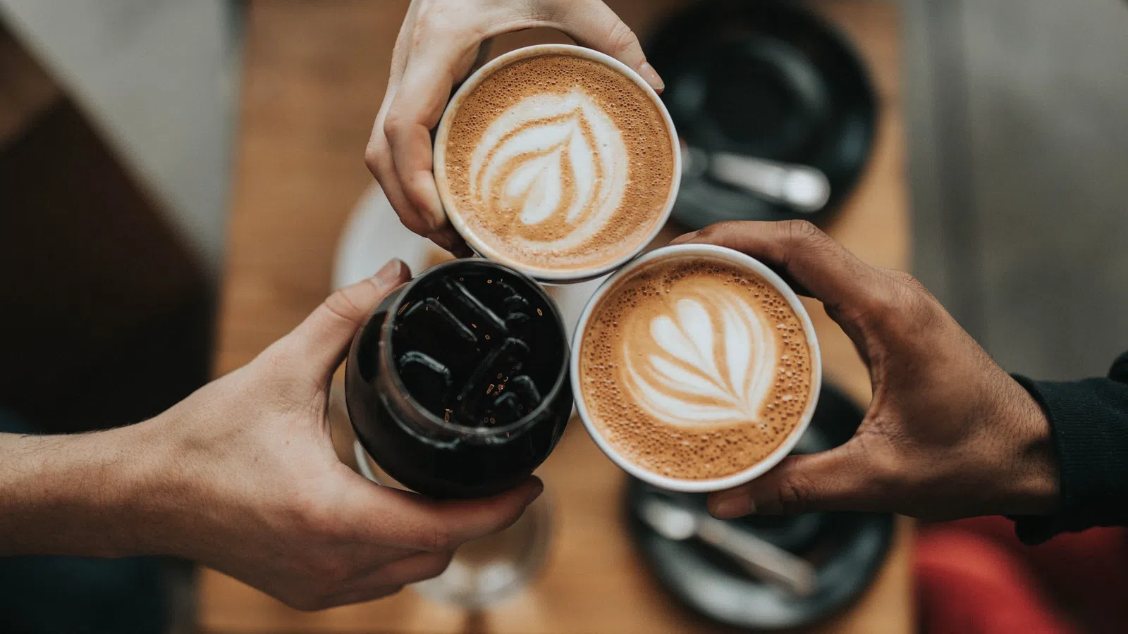 a person holding a couple of coffee cups with foam on them