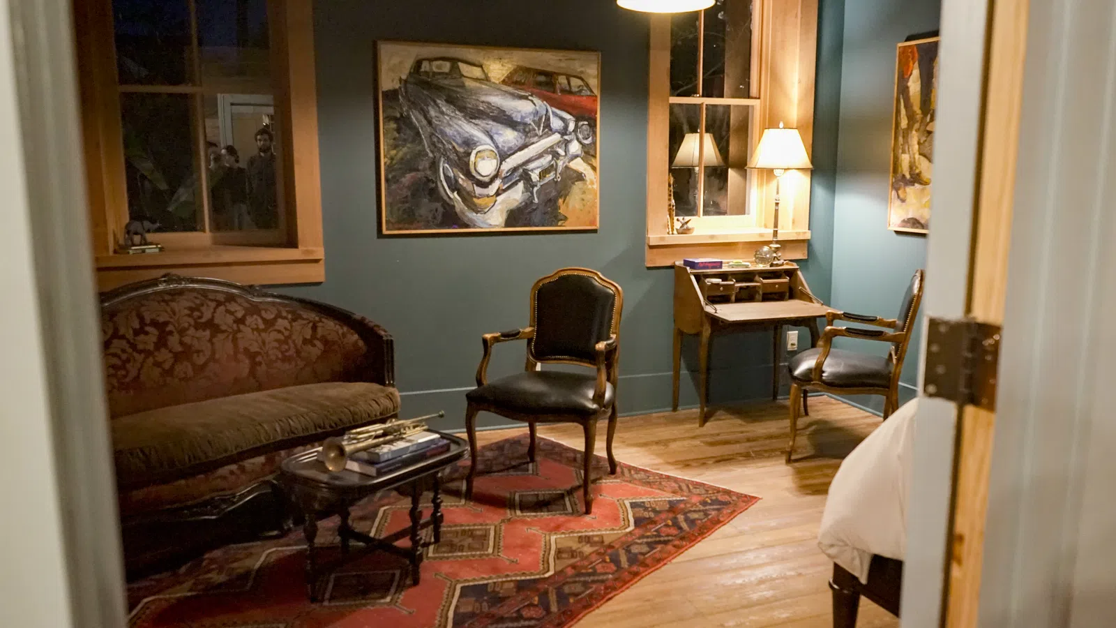 a living room with a desk and chairs