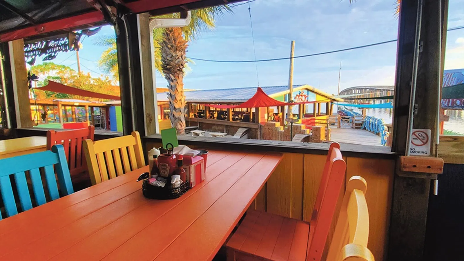 a table with chairs and a boat in the background