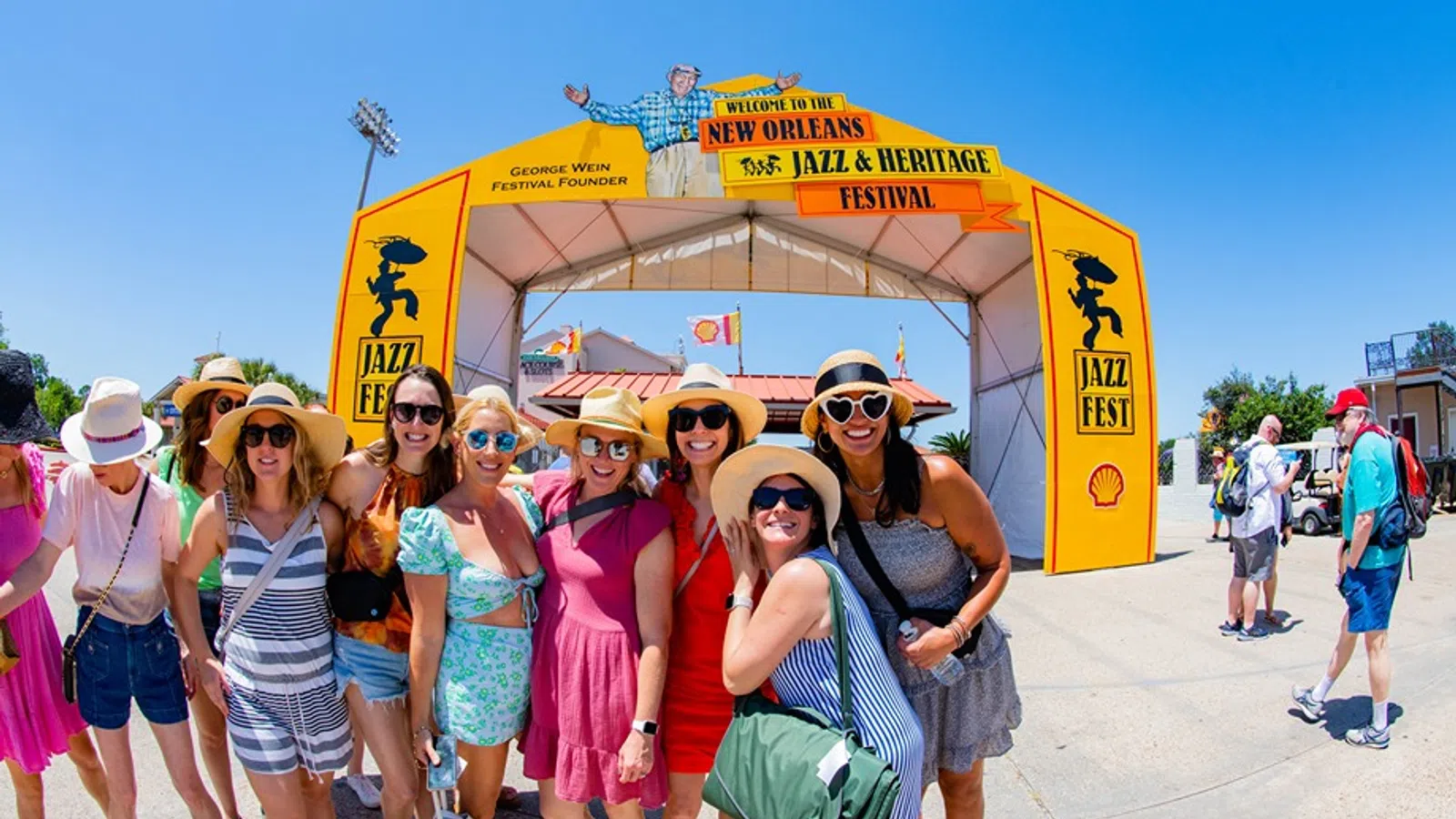 a group of people posing for a photo in front of a yellow tent