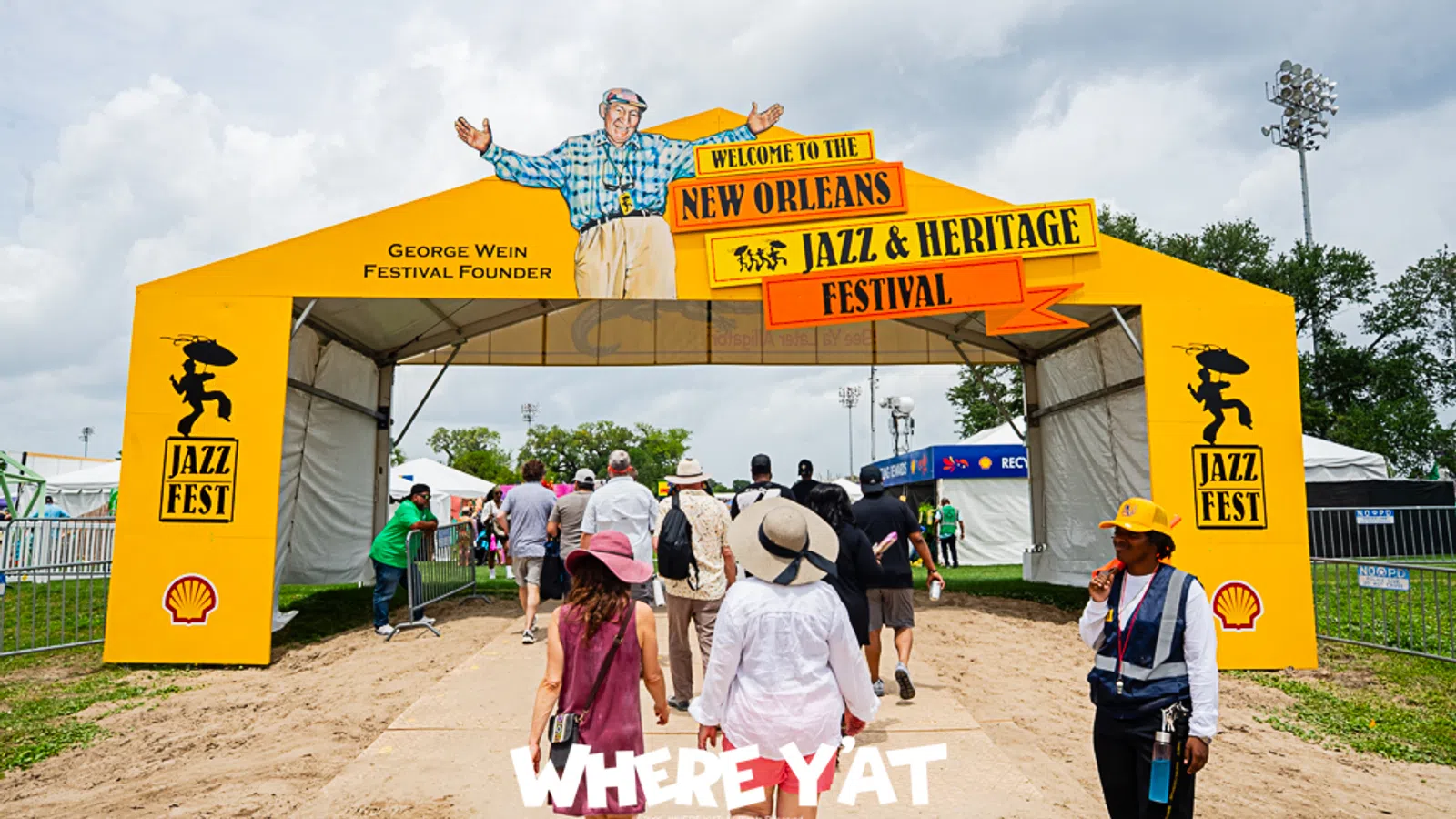 Entrance to the New Orleans Jazz and Heritage Festival with colorful signage and attendees.