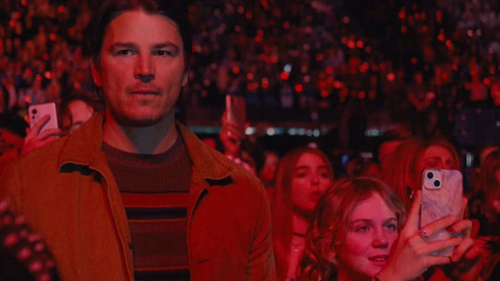 Josh Hartnett holding a cell phone in a crowd