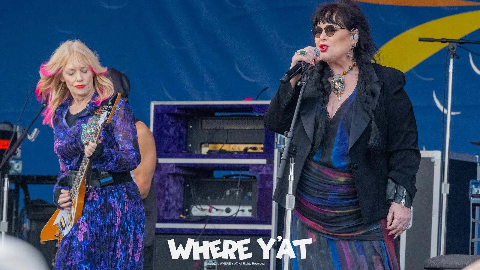Ann Wilson et al. singing into microphones on a stage