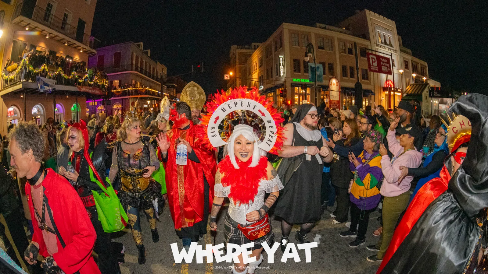 a group of people in clothing on a street at night