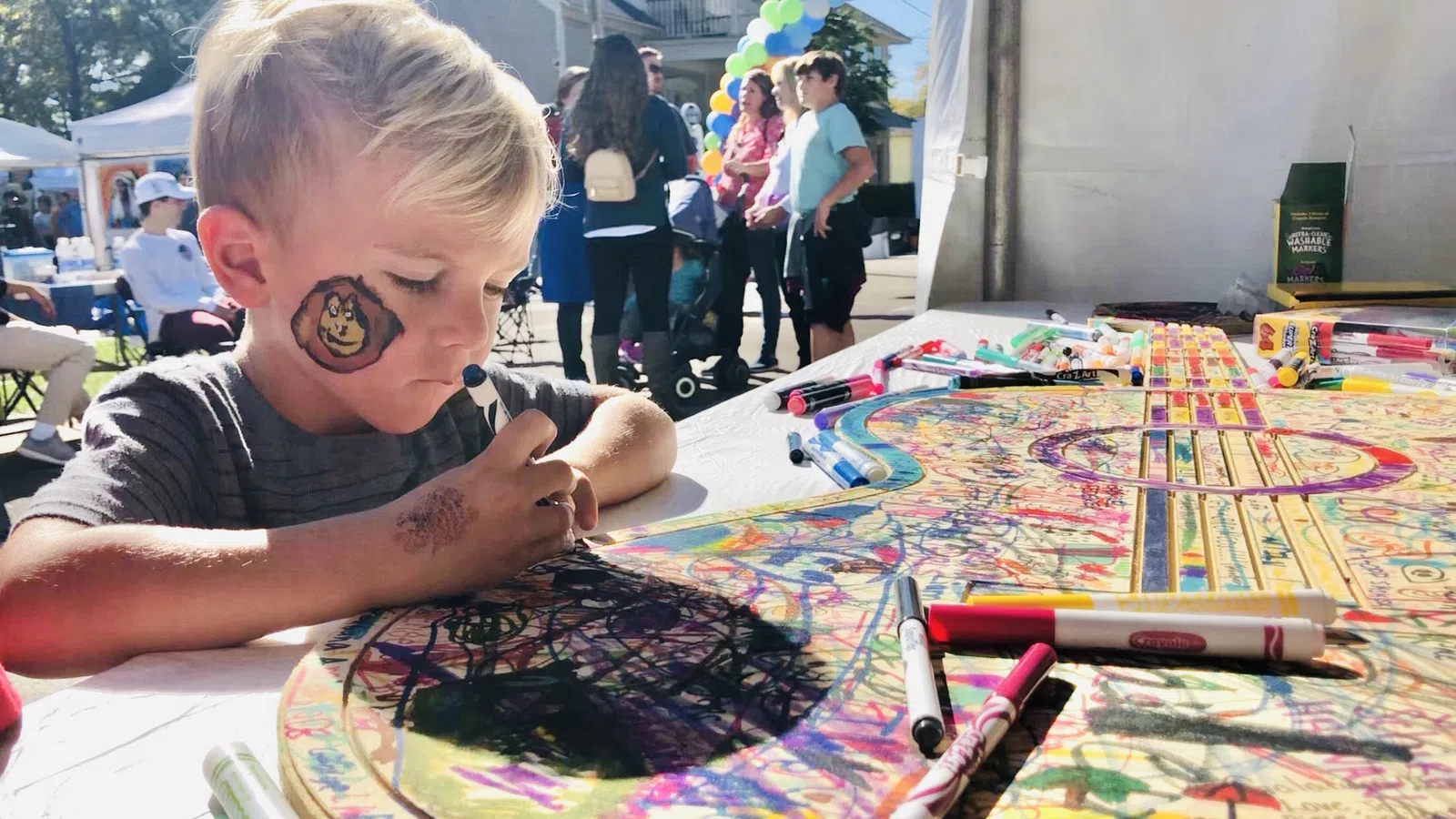a boy sitting at a table with a drawing on it