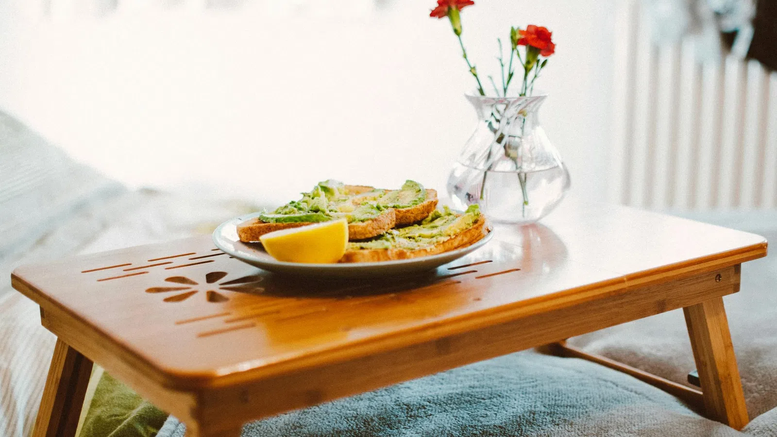 a plate of food and a vase of flowers on a table