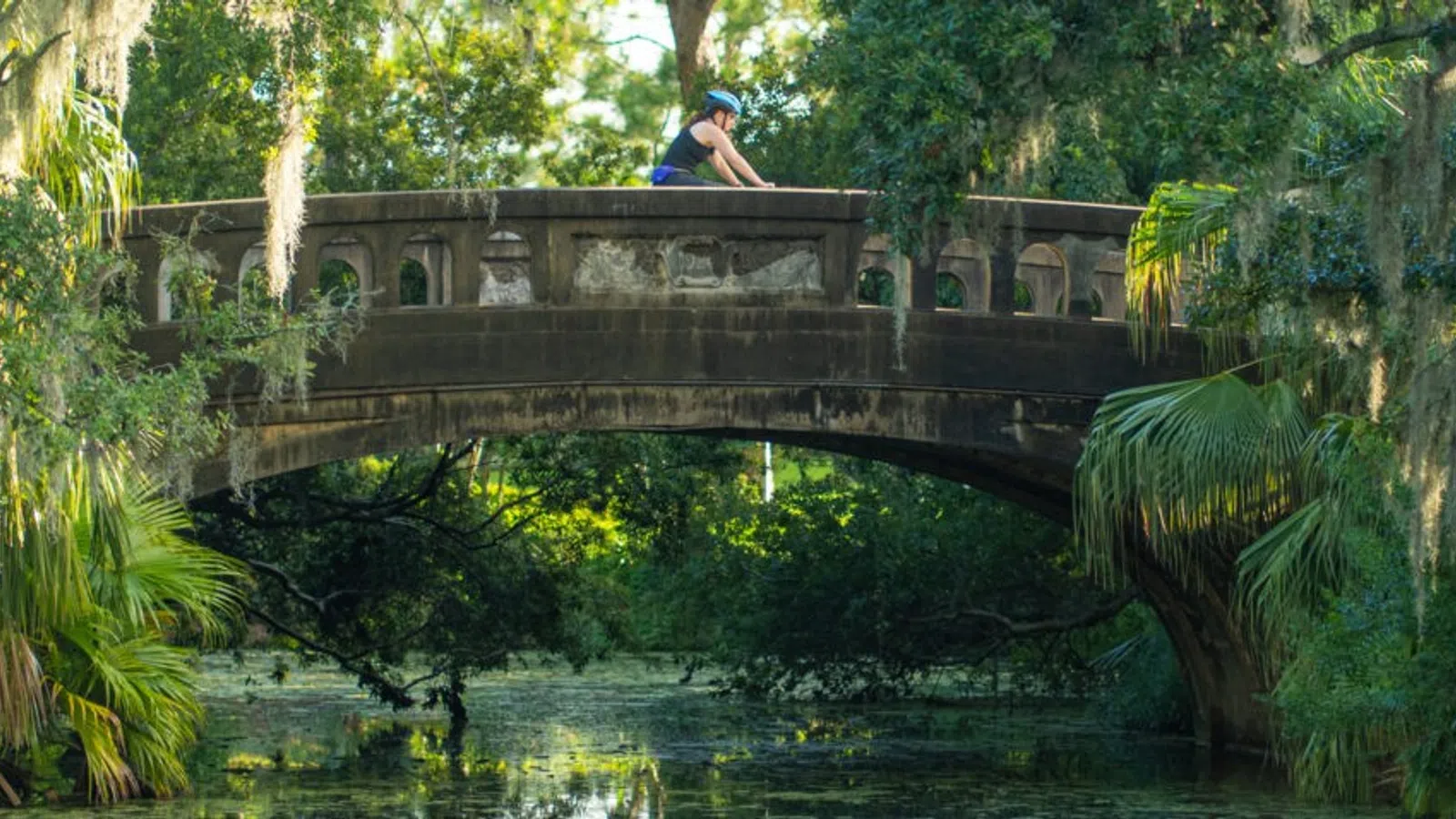 a person sitting on a bridge over water