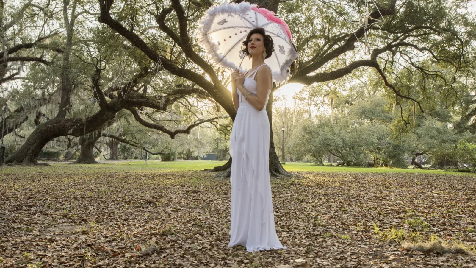 a person in a white dress holding an umbrella