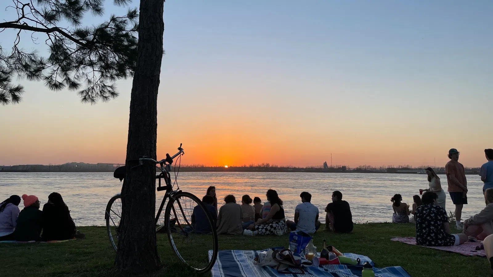 a group of people sitting on a bench by the water