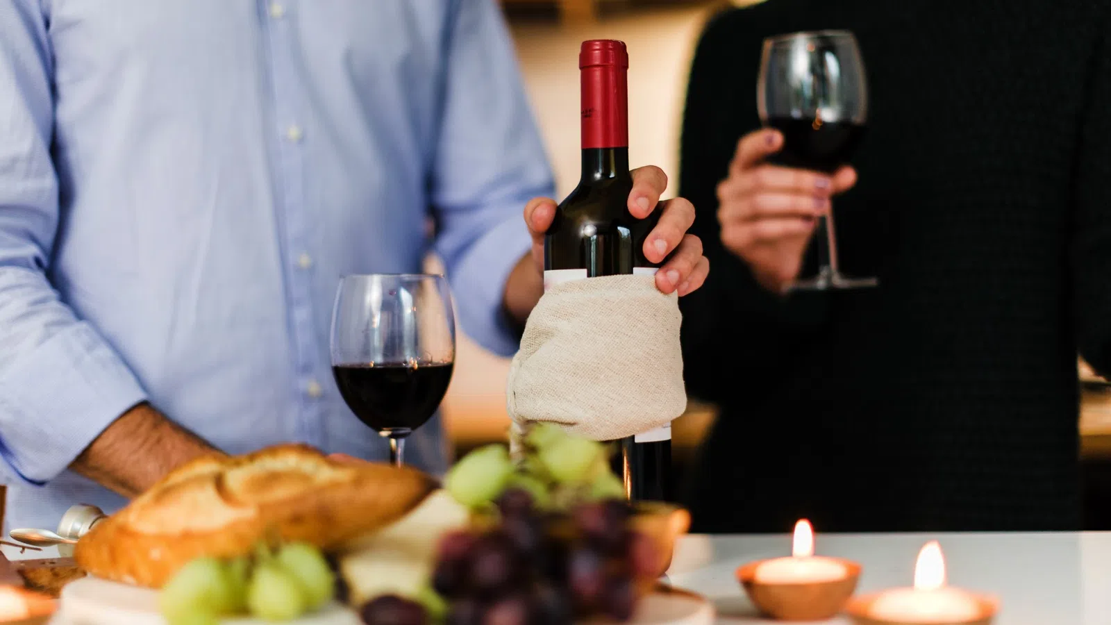 a couple of people holding wine glasses and a plate of food