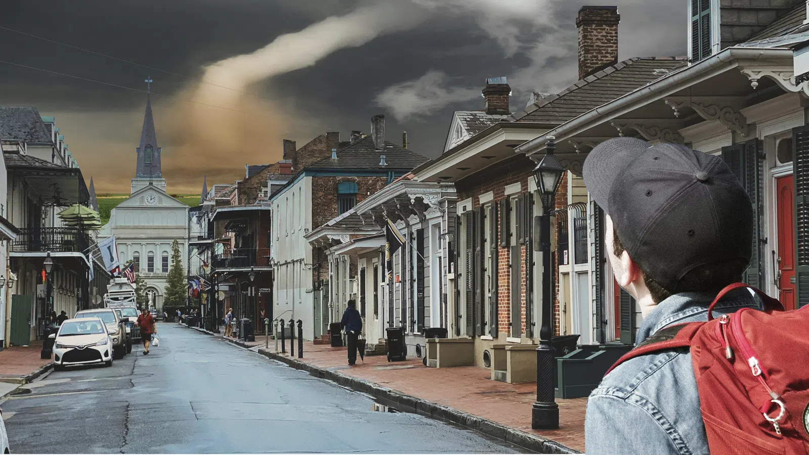 a person in a red coat on a street with buildings and a cloudy sky