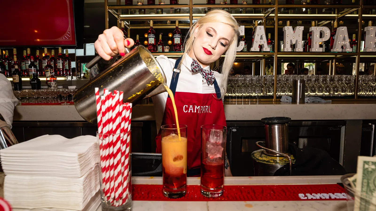 a person pouring a drink into a glass