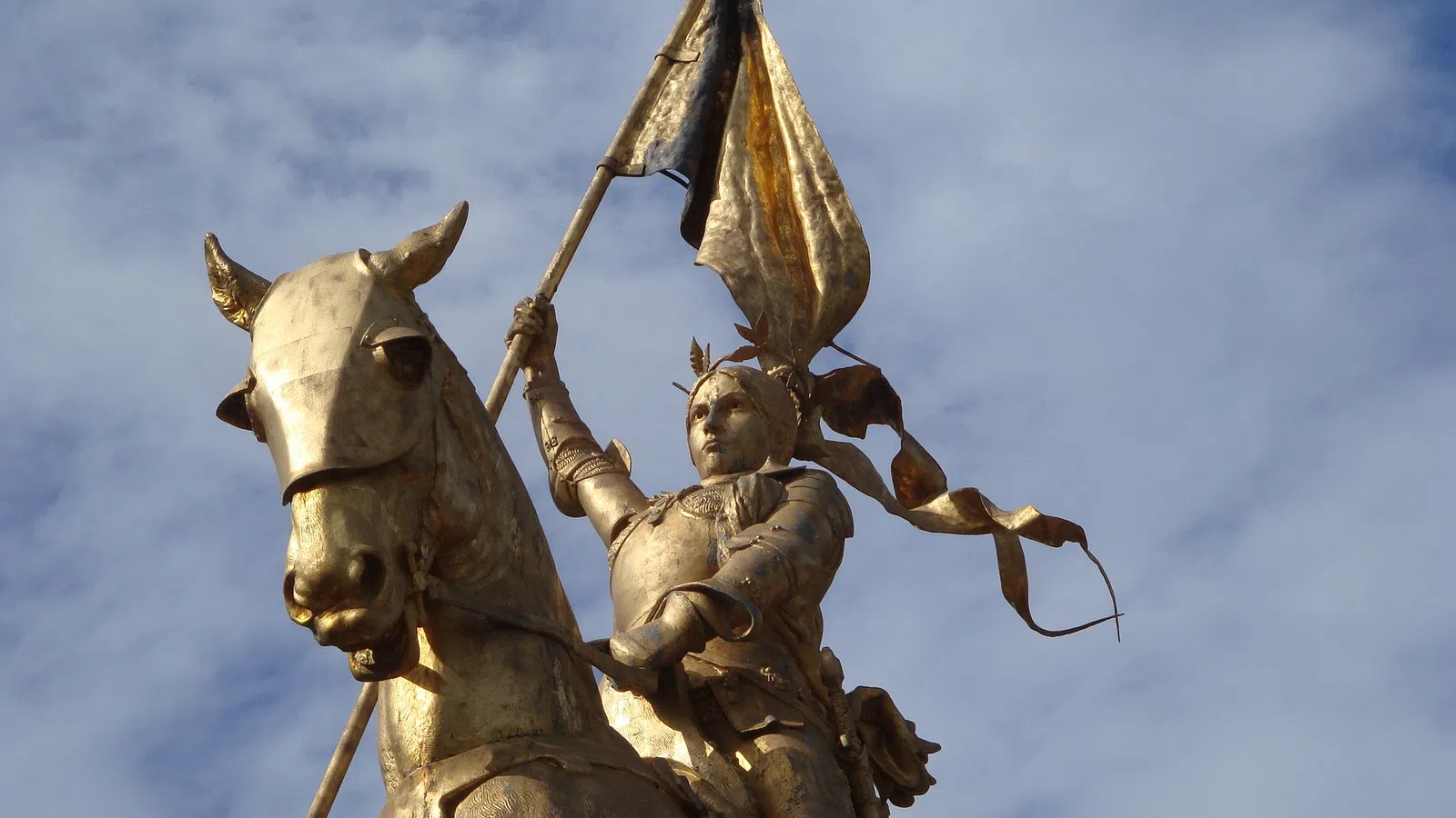a statue of a man riding a horse with a sword and a woman on a horse