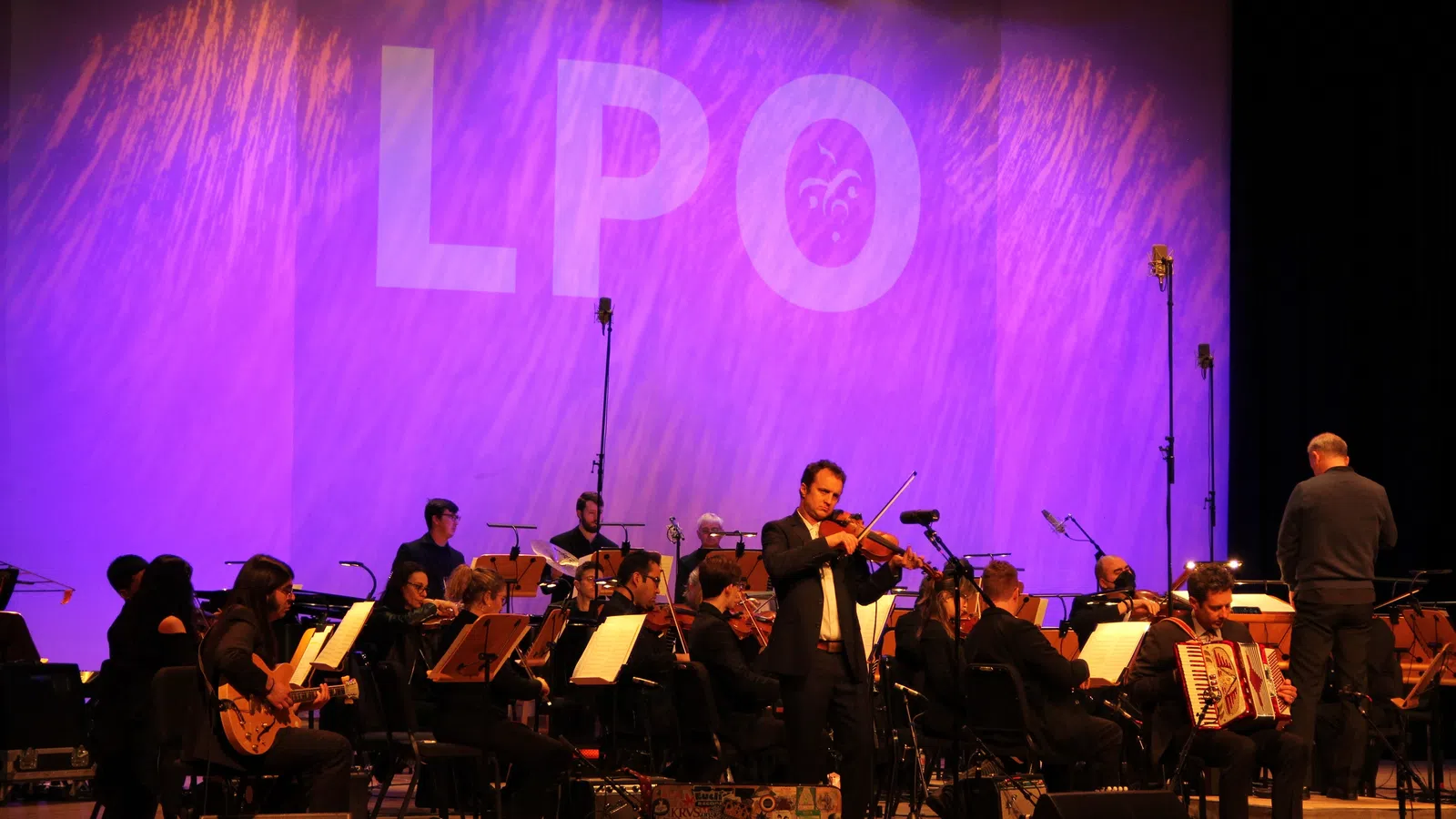 a group of people playing instruments on a stage