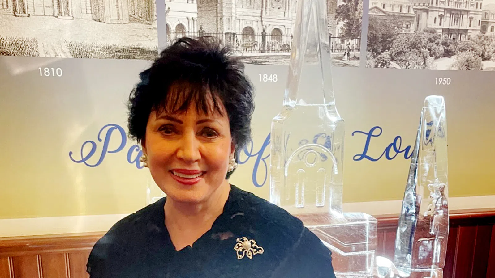 Tom Benson smiling in front of a glass bottle