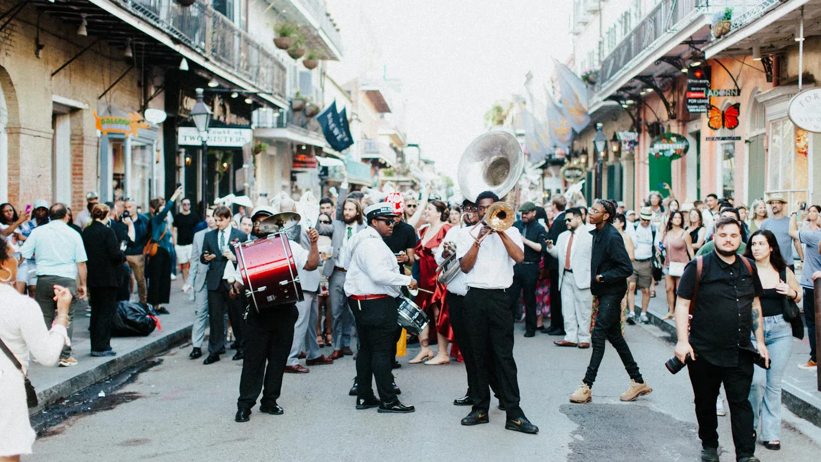 Street parade with a lively brass band playing music and a crowd of people enjoying the festive atmosphere.