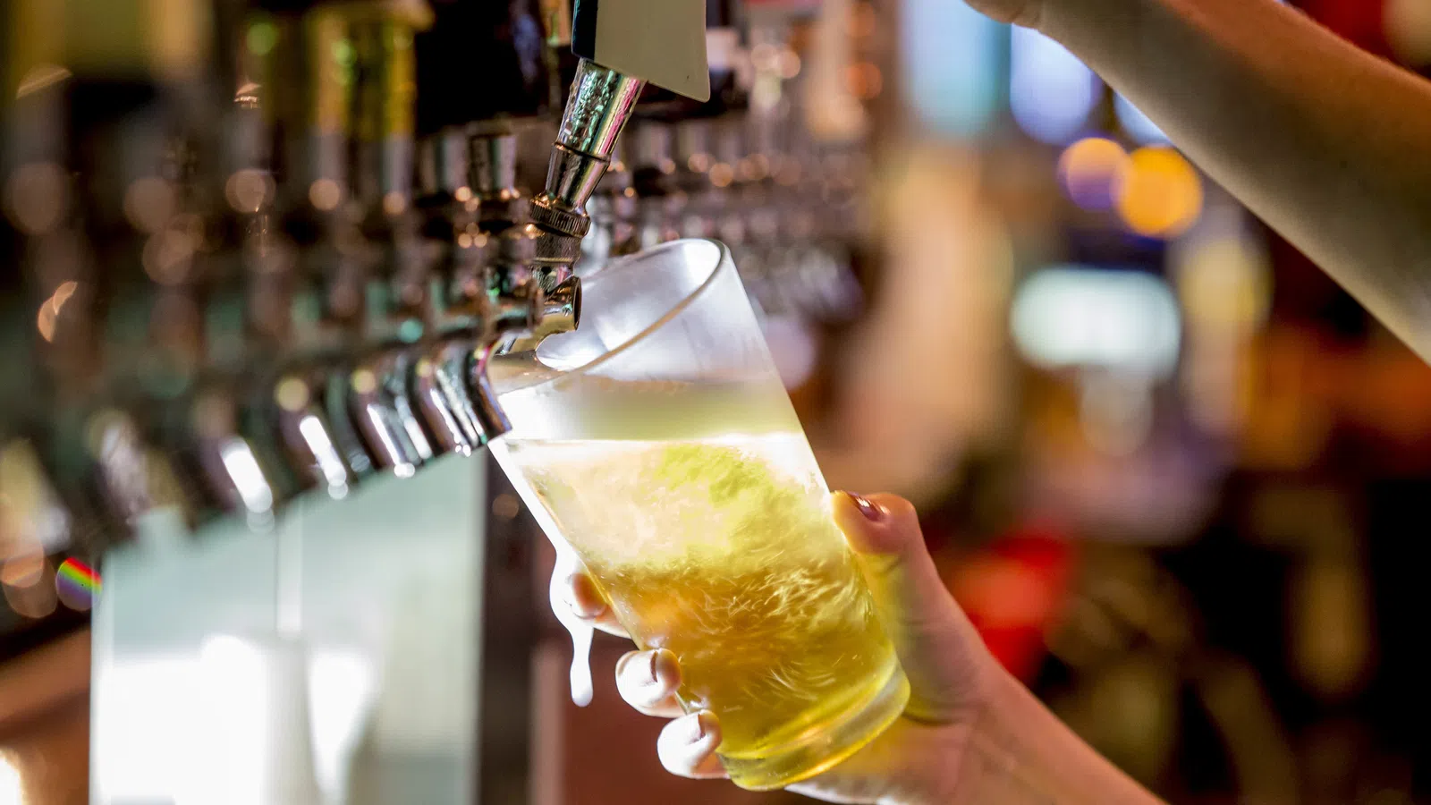 a close-up of a hand pouring a glass of liquid