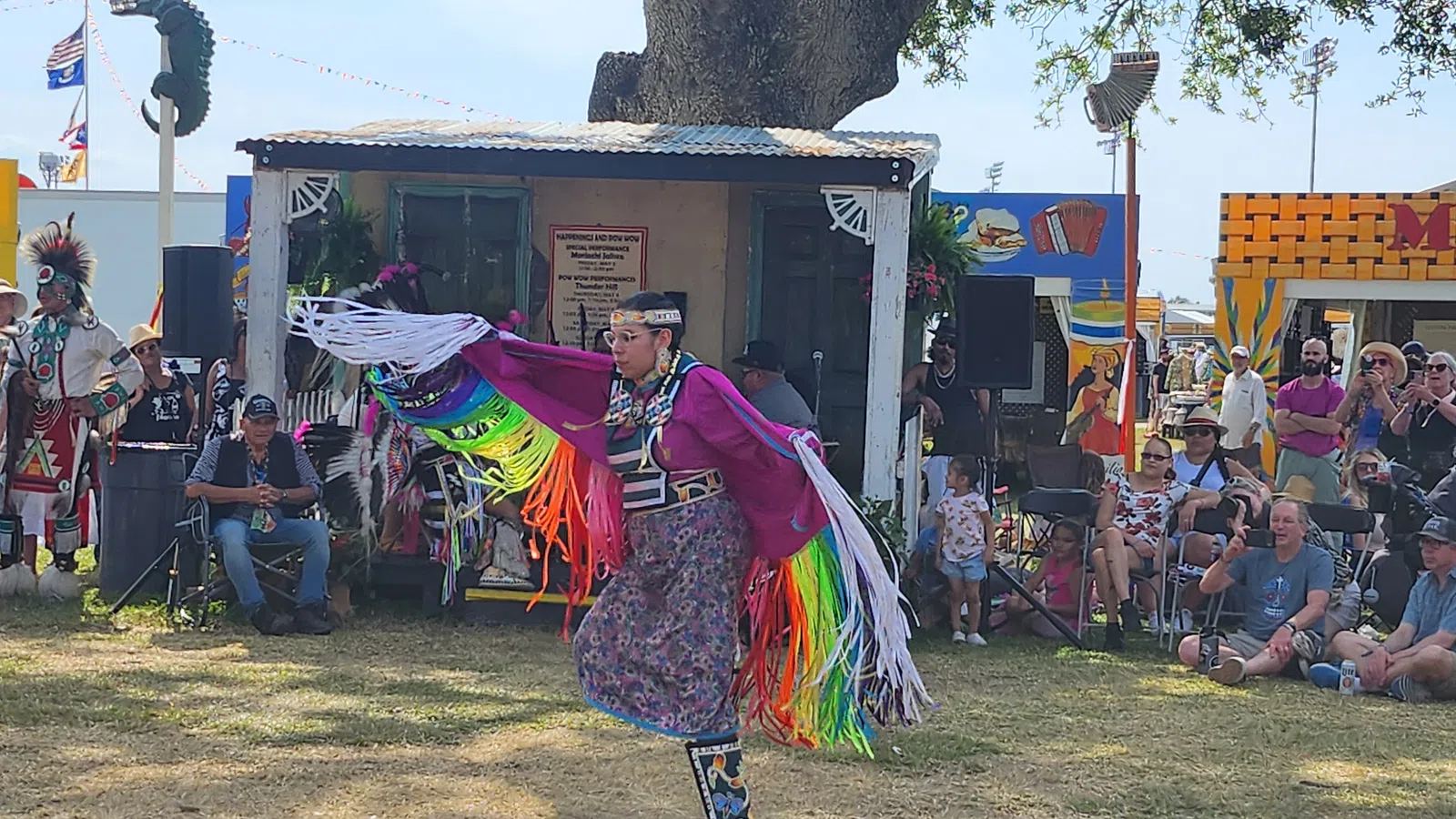 a person in a colorful garment dancing in front of a crowd