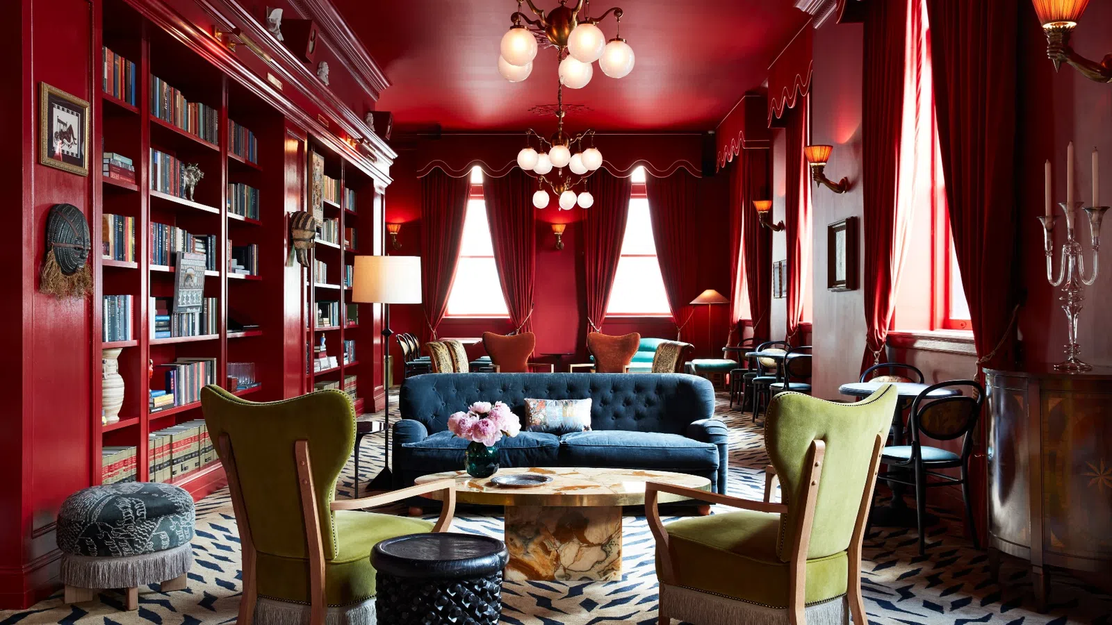 a living room with a blue couch and a red wall