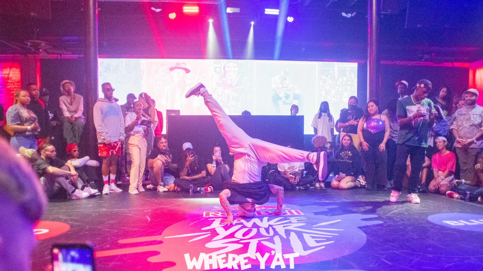 a person doing a handstand on a stage with a crowd watching